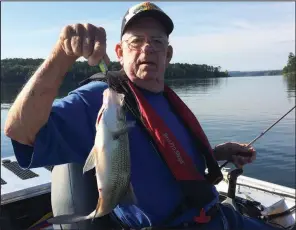  ?? Arkansas Democrat-Gazette/BRYAN HENDRICKS ?? J.O. Brooks of Little Rock hoists one of the big white bass he caught Tuesday while fishing with Rusty Pruitt and the author.