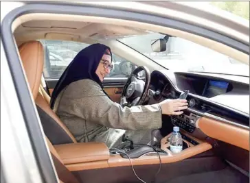  ?? FAYEZ NURELDINE/AFP ?? Saudi national and newly licensed Reem Farahat, an employee of Careem, a chauffeur car-booking service, prepares for a customer in the Saudi capital of Riyadh on Sunday.