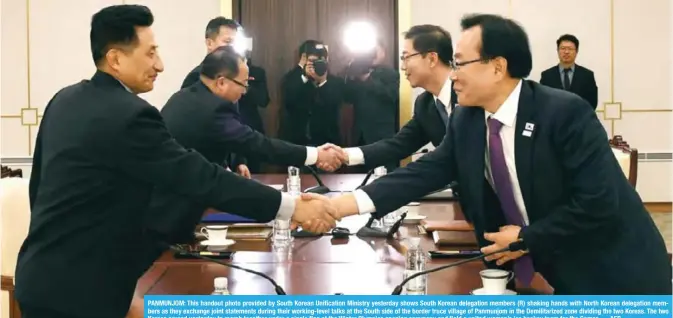  ?? — AFP ?? PANMUNJOM: This handout photo provided by South Korean Unificatio­n Ministry yesterday shows South Korean delegation members (R) shaking hands with North Korean delegation members as they exchange joint statements during their working-level talks at the...