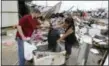  ?? MELISSA PHILLIP /HOUSTON CHRONICLE VIA AP ?? Kenneth Byrant and his wife, Jennifer Byrant, search through debris from Bryant’s Auto Sales in Katy, Texas after a possible tornado during Hurricane Harvey on Aug. 26. They were looking for cars keys and paperwork.