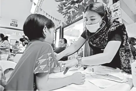  ?? MACKY LIM ?? INHALE, EXHALE. A doctor checks the breathing of a young girl during yesterday’s medical mission at Barangay 74-A Matina Crossing Barangay Hall as the girl had cough for several days already.