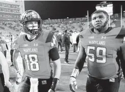  ?? ROB CARR/GETTY IMAGES ?? Quarterbac­k Max Bortenschl­ager, left, and lineman Keiron Howard walk off the field after the Terps closed with their seventh loss in eight games.