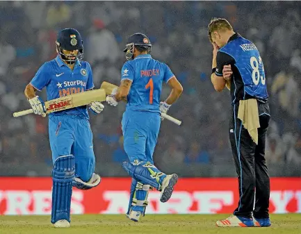  ??  ?? Jimmy Neesham sums up New Zealand’s frustratio­n as India’s Virat Kohli, left, rumbles on towards 154 not out in Mohali.