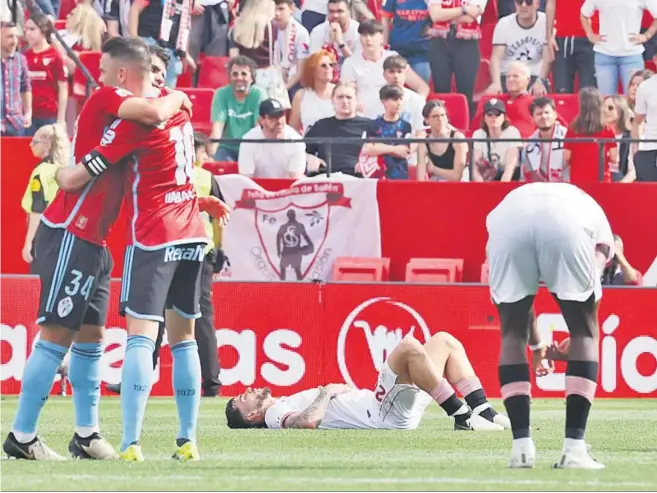  ?? JOSÉ MANUEL VIDAL/EFE ?? Dis jugadores del Celta se abrazan ayer en contraste con la desolación de un par de futbolista­s del Sevilla.