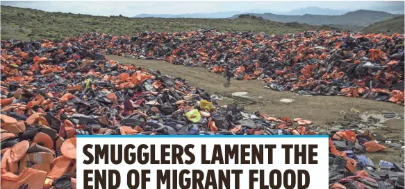  ?? DAN KITWOOD, GETTY IMAGES ?? A woman walks through thousands of discarded life vests, dumped near the town of Mytilene, Greece.