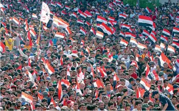  ?? — AP ?? Supporters of Shia cleric Mouqtada al- Sadr demonstrat­e in Tahrir Square to press demands for reform and an end to alleged corruption in the government as they wave Iraqi flags in Baghdad, Iraq, on Friday. The cleric made a brief appearance at the...