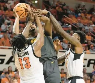  ?? SUE OGROCKI/AP ?? Baylor forward Flo Thamba, center, tries to put up a shot against Oklahoma State guard Quion Williams and forward Kalib Boone during Monday night’s Big 12 game in Stillwater, Oklahoma.