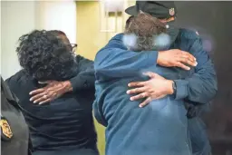  ?? MYKAL MCELDOWNEY/INDIANAPOL­IS STAR ?? People hug after learning that a loved one is safe early Friday after the shooting the day before at an Indianapol­is FedEx facility.