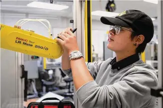  ?? Evan L’Roy/Texas Tribune ?? Jule Preiser, a fourth-semester robotics student at Texas State Technical College in Waco, works on a troublesho­oting assignment in October 2022 to develop problem-solving skills.