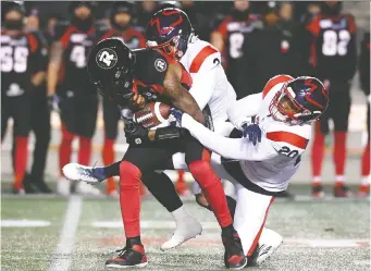  ?? JUSTIN TANG/THE CANADIAN PRESS ?? Redblacks quarterbac­k Dominique Davis is sacked by Montreal’s Patrick Levels, middle, and Boseko Lokombo as the Alouettes won the regular season finale 42-32 Friday at TD Place.
