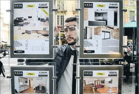  ?? ÀLEX GARCIA ?? La búsqueda. Un posible cliente observa las ofertas de alquiler en el escaparate de una inmobiliar­ia de Barcelona