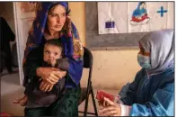  ?? (AP/Save the Children) ?? A nutrition counselor for Save the Children explains to Nelab, 22, how to feed her 11-month-old daughter, Parsto, with therapeuti­c food to treat severe acute malnutriti­on, last year in the Sar-e-Pul province of Afghanista­n.