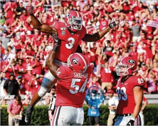  ?? CURTIS COMPTON / CCOMPTON@AJC.COM ?? Zamir White gets a hoist from offensive lineman Justin Shaffer after his touchdown run against Murray State during the second quarter. It was the redshirt freshman’s first TD at Georgia.