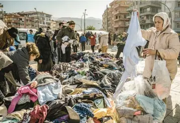  ?? SERGEY PONOMAREV/THE NEW YORK TIMES ?? Earthquake survivors sift through donated clothes Thursday in Antakya, Turkey. President Recep Tayyip Erdogan called the 7.8 magnitude earthquake, which struck Monday,“the disaster of the century.”