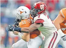  ??  ?? OU defensive end Ronnie Perkins (7) wraps up Texas QB Sam Ehlinger (11) for a loss in the 2018 Big 12 title game. [BRYAN TERRY/THE OKLAHOMAN]