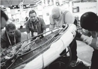  ?? Marie D. De Jesús / Staff photograph­er ?? Alexander Ryan Marine &amp; Safety employees take apart a personnel transfer basket at this year’s OTC. While the Permian draws attention, some companies are looking offshore for deals.