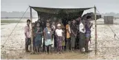  ?? — AFP ?? Rohingya Muslim refugees take shelter from the rain during a food distributi­on at Nayapara refugee camp in Bangladesh’s Ukhia district in this file photo.