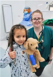  ?? ?? The Vets Klinic open day in Woodley on Saturday received a thumbs up from Hanna with nurse Alice Buddin
Hanna (5) is shown how to bandage a leg on a soft toy dog by Nurse, Alice Buddin