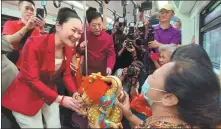  ?? YANG WANLI / CHINA DAILY ?? Sudawan Wangsuphak­itkoson, Thai minister of tourism and sports (left), and Han Zhiqiang, Chinese ambassador to Thailand (center), give gifts to people on board the BTS Skytrain in Bangkok on Friday.