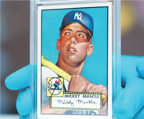  ?? DAVID ZALUBOWSKI / THE ASSOCIATED PRESS ?? This 1952 Topps Mickey Mantle, which was put on display as part of baseball memorabili­a exhibit at the Colorado History Museum on Monday, is owned by Denver lawyer Marshall Fogell and valued at several million dollars.