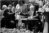  ?? CHIP SOMODEVILL­A/GETTY ?? President Donald Trump shakes hands with Pastor Darrell Scott, co-founder of the New Sirit Revival Center, before signing an executive order Thursday.