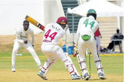  ?? PHOTO BY LENNOX ALDRED ?? Jamaica Scorpions spinner Peat Salmon (left) dismisses Leeward Islands Hurricanes batsman Jahmar Hamilton, as wicket-keeper Romaine Morris looks on during the second day of their West Indies Championsh­ip match at Sabina Park.