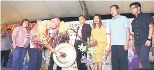  ??  ?? RASMI: Minos memukul gong tanda simbolik pelancaran Pasar Raya Farley Kota Samarahan sebagai Ejen Bank Simpanan Nasional sambil disaksi (dari kanan) Eisang, Lau, Emy dan Harjimi.