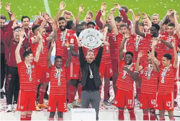  ?? AFP ?? Coach Julian Nagelsmann holds the trophy as Bayern Munich celebrate winning the Bundesliga title.