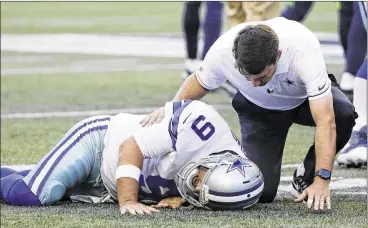  ?? ELAINE THOMPSON / AP ?? Dallas quarterbac­k Tony Romo is tended to after he went down awkwardly on the third play of Thursday night’s preseason game at Seattle. Romo walked off on his own but was replaced by Dak Prescott.