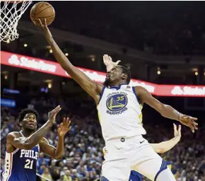  ??  ?? Back on form: Golden State Warriors’ Kevin Durant (right) lays up a shot over Philadelph­ia 76ers’ Joel Embiid (left) during the first half of their NBA game on Saturday. — AP