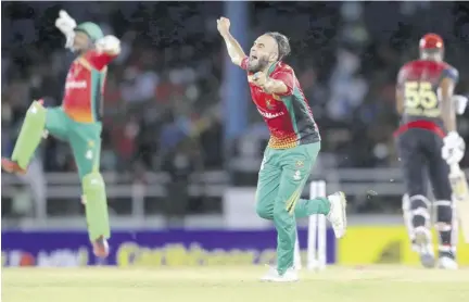  ?? (Photo: Observer file) ?? Imran Tahir and Nicholas Pooran of Guyana Amazon Warriors celebrate the wicket of Kieron Pollard of Trinbago Knight Riders during the Hero Caribbean Premier League match between Trinbago Knight Riders and Guyana Amazon Warriors at Queen’s Park Oval on September 30, 2019 in Port of Spain, Trinidad And Tobago.