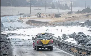  ?? CP PHOTO ?? Sea water and debris block Highway 207 in Lawrenceto­wn, N.S., on Friday. A winter storm hit Nova Scotia, New Brunswick, P.E.I. and parts of Newfoundla­nd and Labrador, with wind, rain and heavy snow in places.