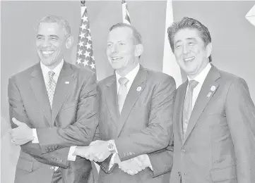  ??  ?? Obama (left), Abbott and Abe meet at the G20 summit in Brisbane. — Reuters photo