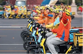  ??  ?? 1 de octubre de 2019. Un grupo de repartidor­es de entrega rápida hace su aparición en el desfile por el Día Nacional, provocando una gran ovación en la Plaza Tian’anmen.