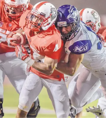  ?? ROBERTO E. ROSALES/JOURNAL ?? University of New Mexico running back Romell Jordan tries to run through the tackle attempt of Abilene Christian’s Gavin Buford during Saturday’s game. Jordan carried three times for 65 yards in the Lobo’s 38-14 win.
