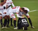 ?? Photograph: Ander Gillenea/AFP/Getty Images ?? Sevilla’s players show their appreciati­on for Bono after his decisive penalty save.