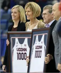  ?? STEPHEN DUNN — THE ASSOCIATED PRESS ?? Connecticu­t head coach Geno Auriemma, second from right, and associate head coach Chris Dailey, second from left, are honored with jerseys commemorat­ing their 1,000th win as coaches of the women’s basketball team Sunday before an NCAA college...