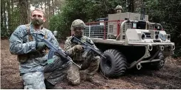  ??  ?? Remote control... troops in training beside a robot vehicle yesterday