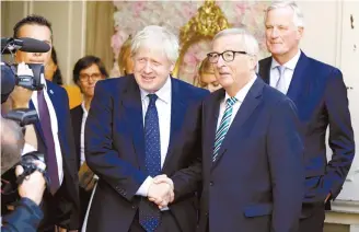  ?? AP-Yonhap ?? European Commission President Jean-Claude Juncker, right, shakes hands with British Prime Minister Boris Johnson prior to a meeting at a restaurant in Luxembourg, Monday.