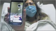  ?? ERIC GAY — THE ASSOCIATED PRESS ?? Clarissa Munoz, who is infected with COVID-19, shares a photo of her baby at DHR Health, Wednesday in McAllen, Texas. Munoz was separated from her child after giving birth.