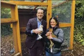  ?? TERRY CHEA — THE ASSOCIATED PRESS ?? Ron End Allison AbtE hold hens in front of their bEckyErd chicken run in Ross on Dec. 15.