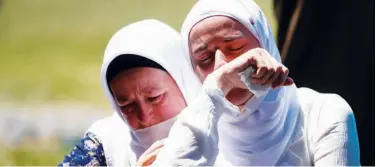  ??  ?? ↑ Women cry at a graveyard during a mass funeral in Potocari near Srebrenica on Saturday.