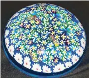  ??  ?? A late 1970’s Murano magnum weight comprised of numerous large blue flower blossoms amidst a closely packed millefiori floral carpet surrounded by a circle of white flower canes.