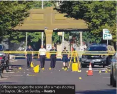  ?? — Reuters ?? Officials investigat­e the scene after a mass shooting in Dayton, Ohio, on Sunday.