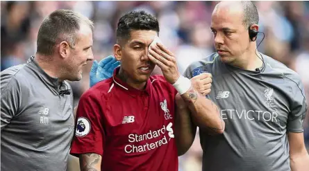  ?? — AP ?? I can see clearly now: Liverpool’s Roberto Firmino holds a patch over his eye after receiving treatment during the English Premier League match against Tottenham Hotspur in London last Saturday.