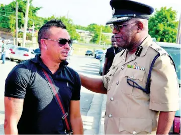  ?? KENYON HEMANS ?? Bishop Dr Gary Welsh (right), assistant commission­er of police in charge of the Public Safety and Traffic Enforcemen­t Branch, speaks with Dennis Dietrih yesterday.