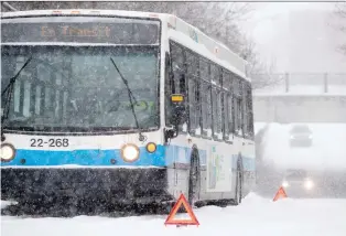  ?? ALLEN McINNIS ?? A disabled STM bus blocks Ste-Marguerite St. after Sunday’s winter storm blew through town.