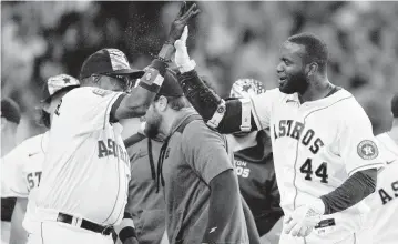  ?? ERIC CHRISTIAN SMITH AP ?? Astros manager Dusty Baker high-fives designated hitter Yordan Alvarez, who hit a walk-off solo home run with two outs in the bottom of the ninth inning Monday to beat the Royals 7-6 and extend Houston’s winning streak to seven.