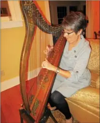  ?? PHOTO SPECIAL TO THE DISPATCH BY MIKE JAQUAYS ?? Bambi Niles plays her vintage harp “Miss Kavanaugh” at her Oneida home on Nov. 14.