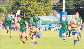  ??  ?? Gene Sario busts through a tackle in AIMS 7s.